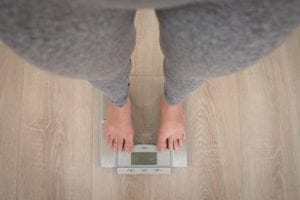 Woman on Scale because of Covid-19 Weight Gain