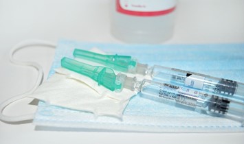 Mask and covid-19 or flu shot vaccination syringes
